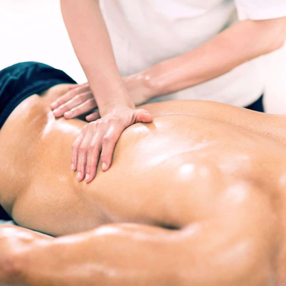 Mężczyzna leżący na kozetce spa podczas masażu sportowego